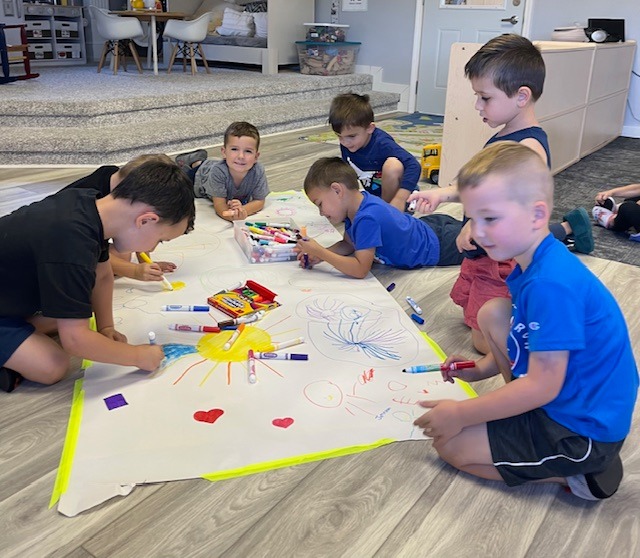 Children drawing together on a large canvas